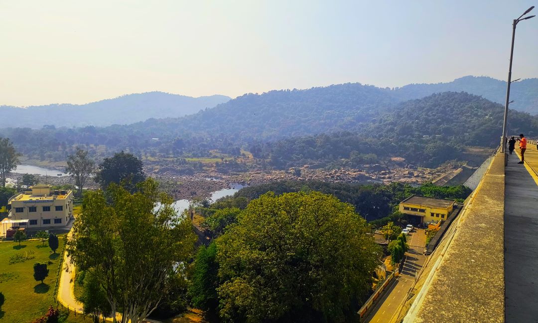 The expansive view from the dam, capturing the river, hills, and surrounding greenery